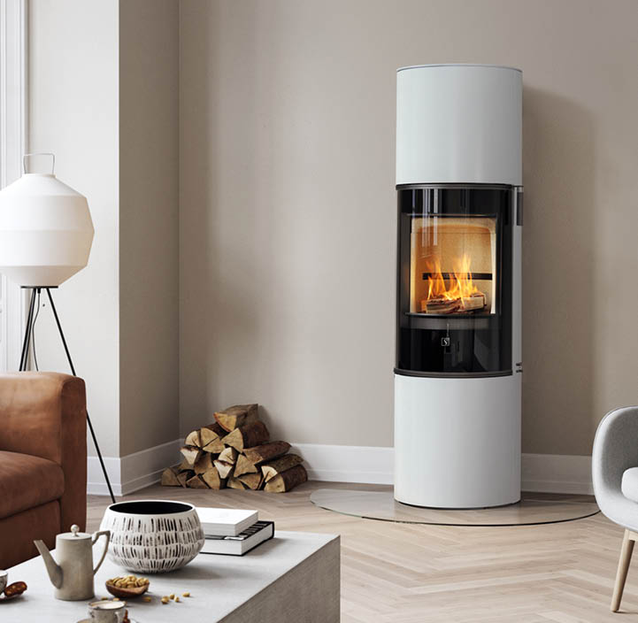 White wood-burning stove Scan 84 with black glass door stands on a floor in a herringbone pattern