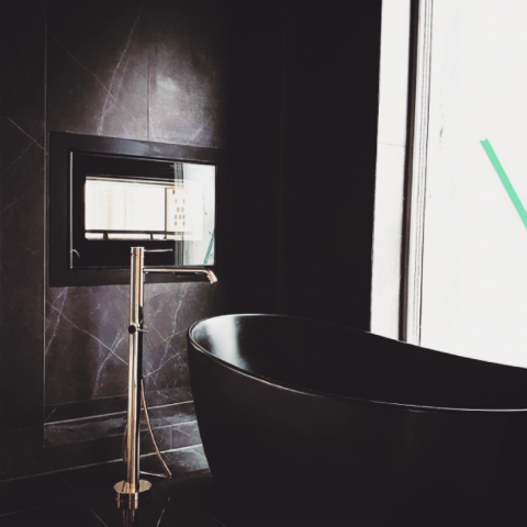 Stor innebygd peis Scan DSA 12 med innsyn fra to sider på et mørkt marmorbad