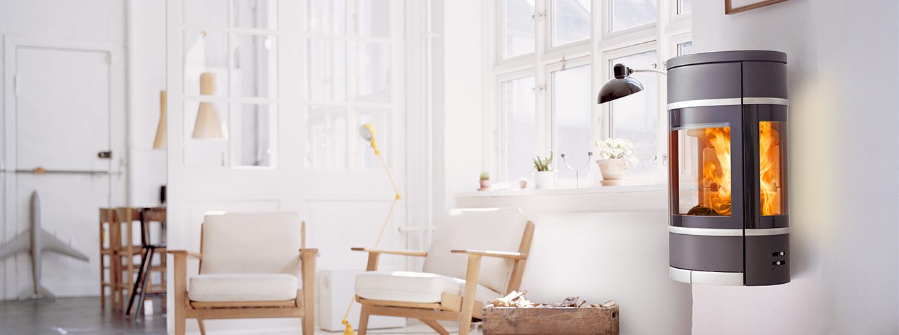 Sort oval vegghengt vedovn med sideglass aluminiumshåndtak og pyntelister Scan 68-8 i hvitt rom med lyse møbler i dansk designstil