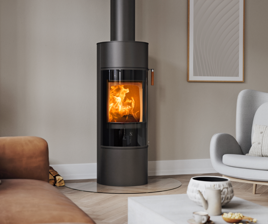 Sort peisovn Scan 84 med sort glassdør I en moderne nordisk stue med brun sofa og lysegrå stol