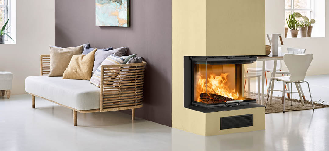 Peis malt gul i et hvitt rom med kjøkken på den ene siden og sofa på den andre