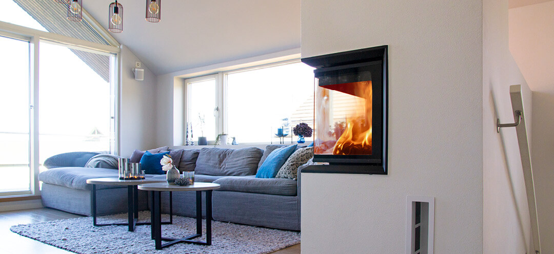 Stor hvit peis med glass på to sider Scan 5003 FR i en moderne stue med blå sofa