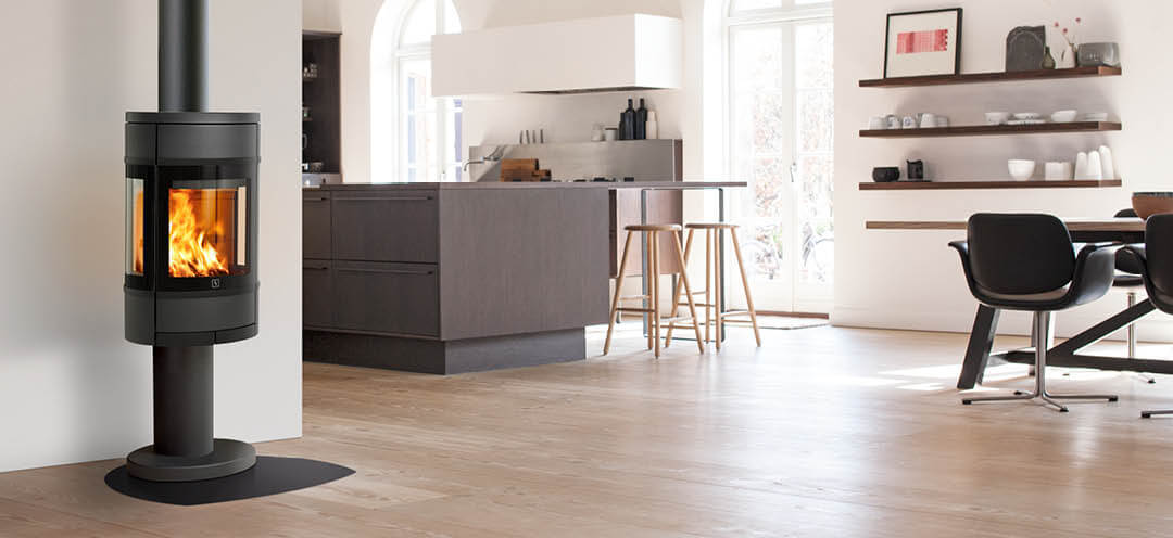 Oval, sort vedovn med sideglass Scan 68-9 på søyle plassert i et lyst kjøkken med moderne brun innredning