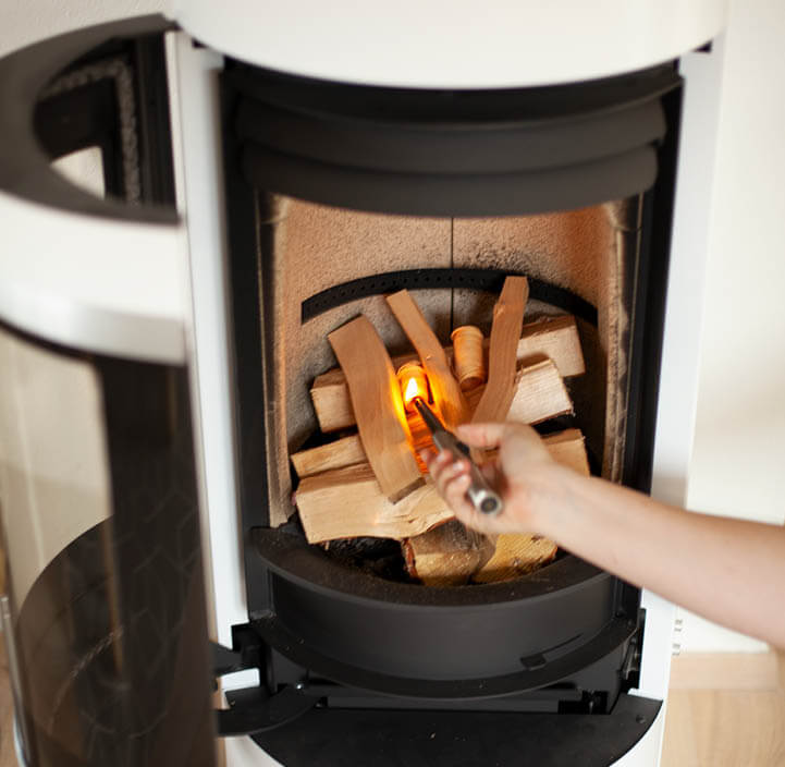 Nærbilde inne i en peisa av avordan man stabler bålet 