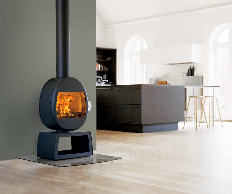 Scan 66-4 liten vedovn med organisk form og åpen sokkel, plassert i moderne og lyst kjøkkenmiljø