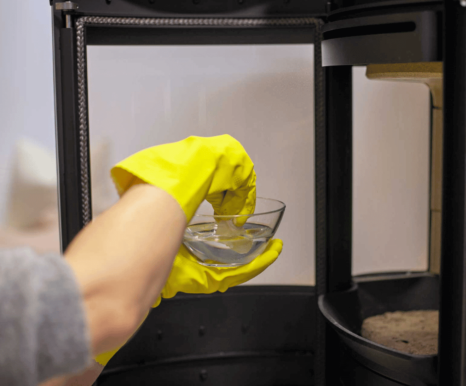 Dypp papir i vann før rengjøring av peisglass – første steg for å fjerne sot på ovnsglasset