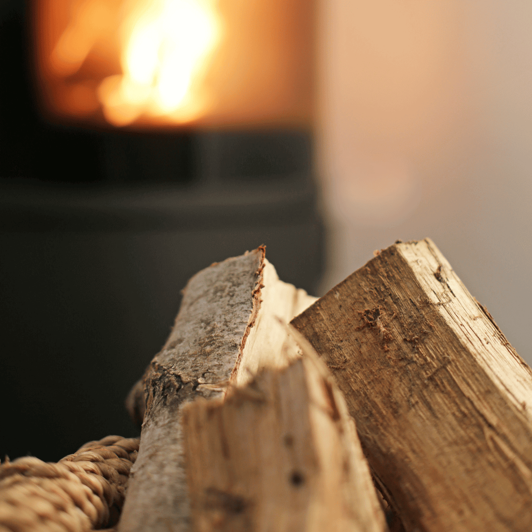 Tørr ved i kurv foran peisovn i drift – perfekt for effektiv fyring og lun atmosfære