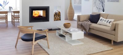 Hvit peis Scan DSA 12 gjennomgående i lyst rom med lyse tremøbler