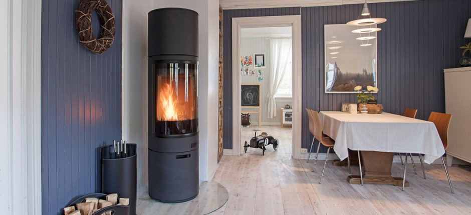 Stor sort peisovn Scan 85 High Top med ekstra varmelagring i et blått skandinavisk kjøkken