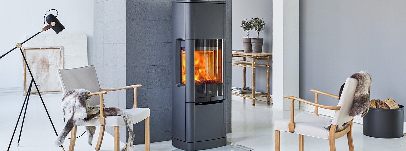 Høy peisovn Scan 65-10 High Top med frontglass og sideglass i lyst rom med grå fliser bak