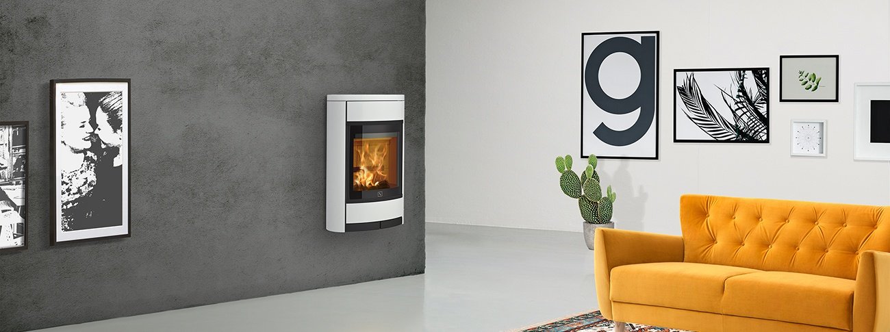 Vegghengt vedovn Scan 68-1 hvit vedovn med stor glassdør i mockup industrielt interiør med gul sofa