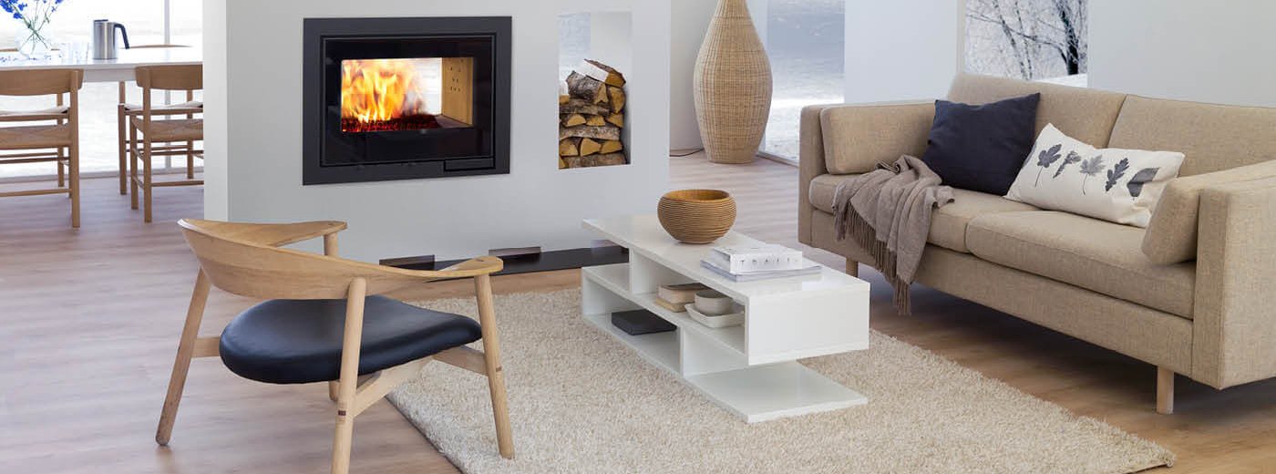 Hvit peis Scan DSA 12 gjennomgående i lyst rom med lyse tremøbler