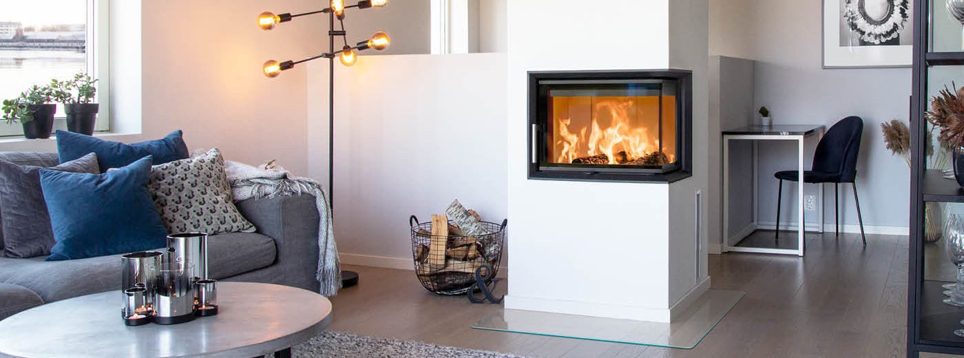 Hvit hjørnepeis med flammer i hvitt moderne hjem med grå sofa og rundt bord