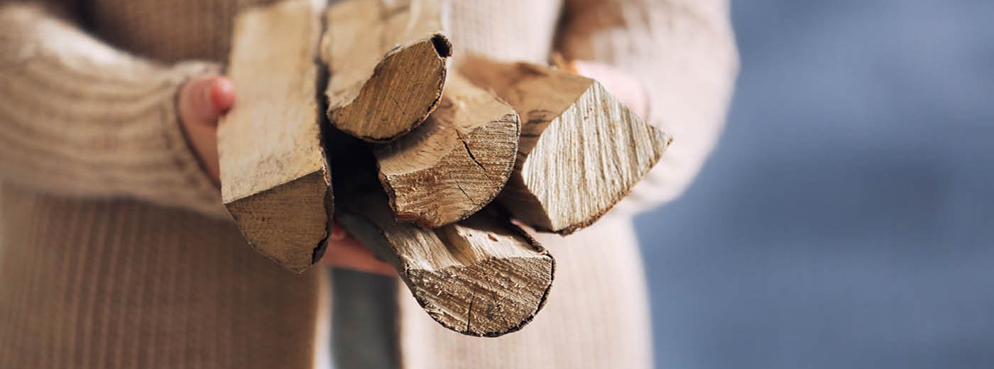 Kvinne med beige cardigan holder ved i hendene