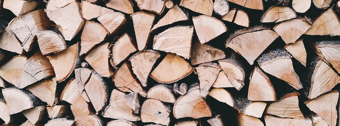 Stabel med kløyvd ved i ulike størrelser og fargetoner